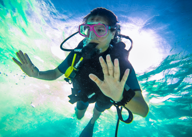 Female scuba diver equalizing the pressure on Oliveli island , M